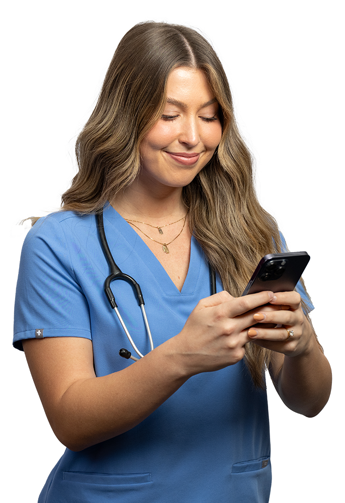 Female Healthcare worker in scrubs smiling using a phone