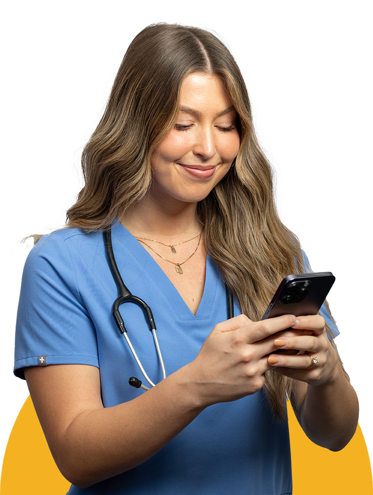 Female Healthcare worker in scrubs smiling using a phone