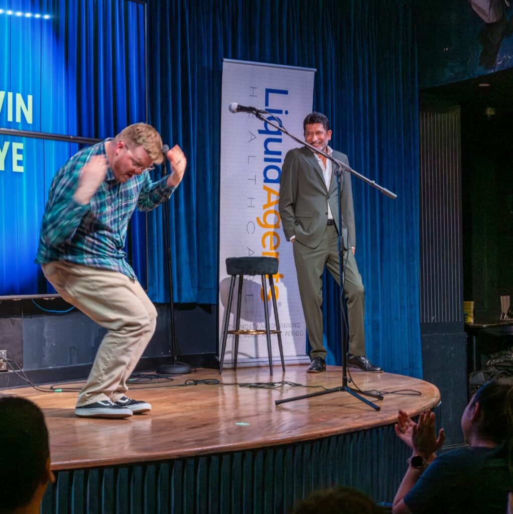 Photo of an employee dancing and the CEO smiling happily in the background