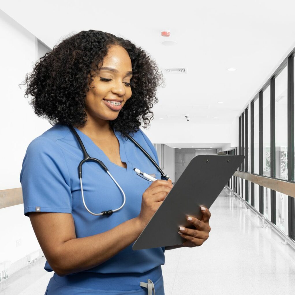 Photo of young woman in scrubs holding a clipboard in a hospital